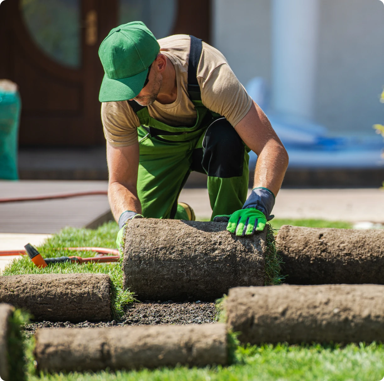 Man installing grass rolls in garden